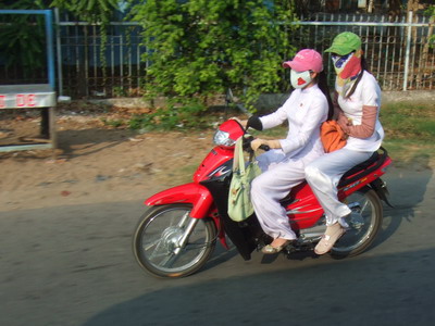 Vietnam - Modedfahrerin mit Atemschutz